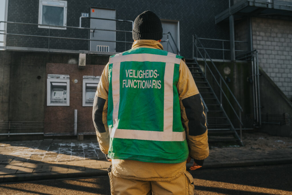 Veiligheidsfunctionaris op terrein van Spinel Veiligheidscentrum voor een gebouw.